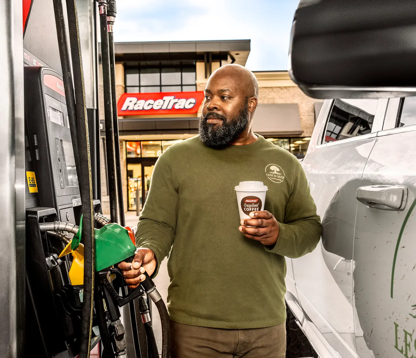 Man pumping gas at RaceTrac holding a Crazy Good Coffee