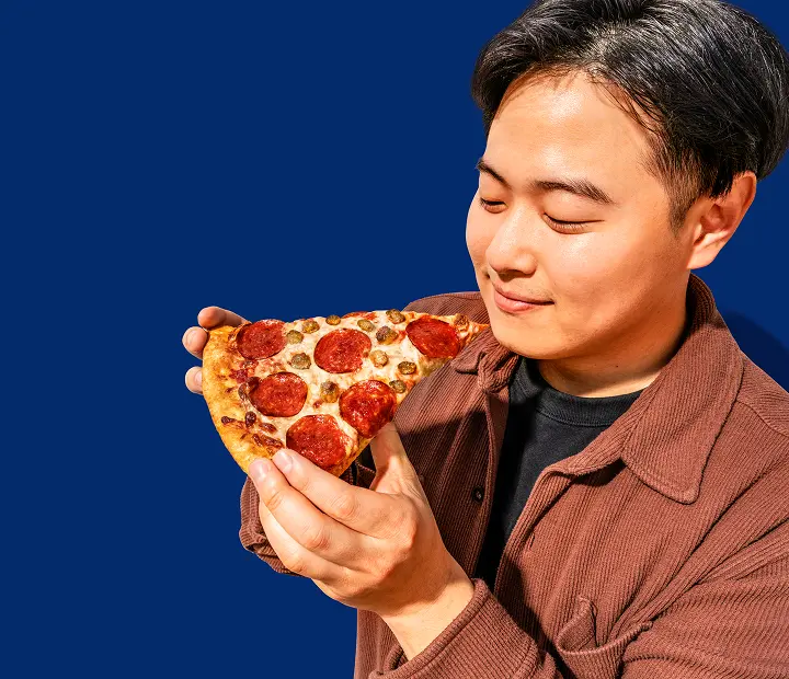 Man eating a slice of RaceTrac pizza