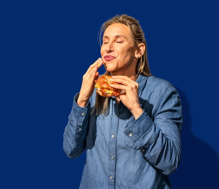 Woman eating RaceTrac breakfast sandwich